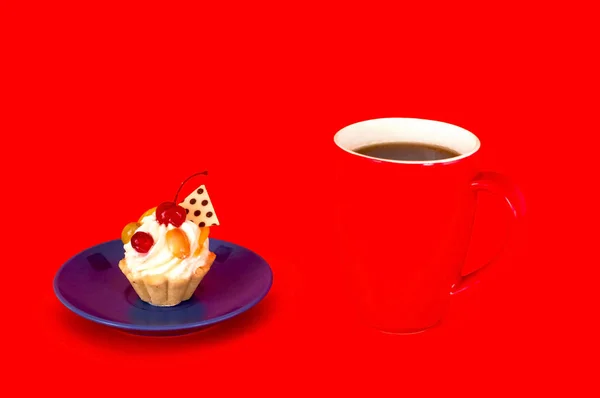 Stor röd kopp kaffe och cupcake med körsbär på bakgrund av koraller. Kopiera utrymme. — Stockfoto