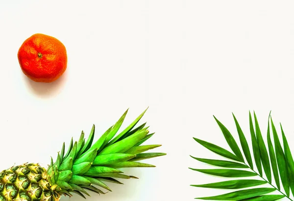 Tropiska bakgrunden med ananas. Mandarin och palm lämnar på isolerade vit bakgrund. — Stockfoto