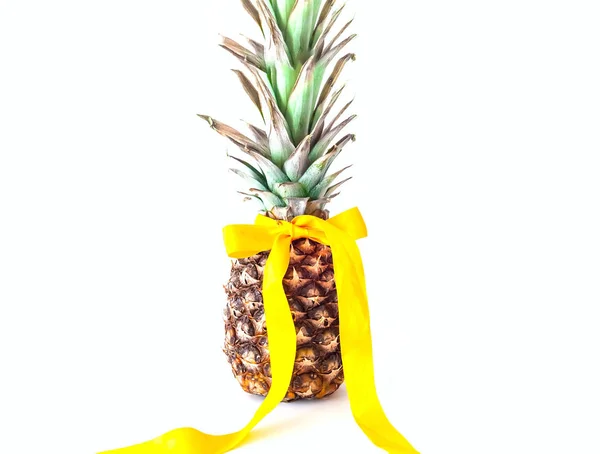 Piña con cinta amarilla sobre fondo blanco aislado. Decoración festiva . — Foto de Stock