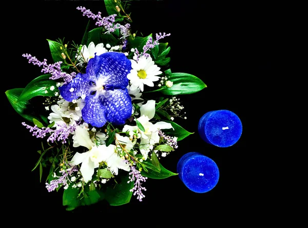 Ημέρα του Αγίου Βαλεντίνου έννοια. Όμορφη ανθοδέσμη από ανοιξιάτικα λουλούδια και μπλε κεριά σε μαύρο φόντο. — Φωτογραφία Αρχείου