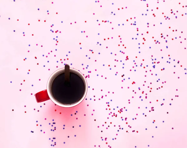 Fincan kahve ve pembe pastel zemin üzerine pembe Fiyonklu hediye kutusu parıldıyor. Festival kavramı.  