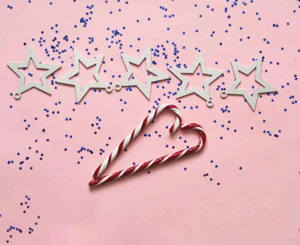 Corazón de caramelo y estrellas blancas sobre fondo rosa pastel de moda. Fondo festivo para paquetes y proyectos . — Foto de Stock