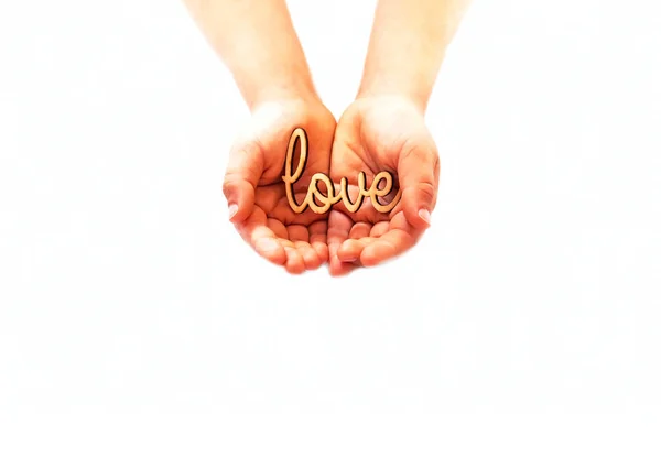 Pequenas mãos de criança seguram na palma da mão de carimbar a palavra amor. Conceito festivo . — Fotografia de Stock