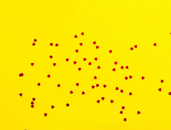 ハートの形のスパンコールでお祝いの黄色の背景. — ストック写真