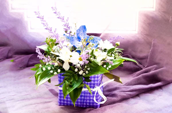 Bellissimo bouquet di fiori primaverili su texture viola su sfondo finestra . — Foto Stock
