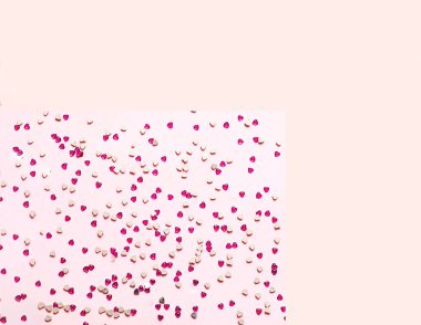 Kalp şeklinde kırmızı payetler ile şenlikli pembe arka plan. 