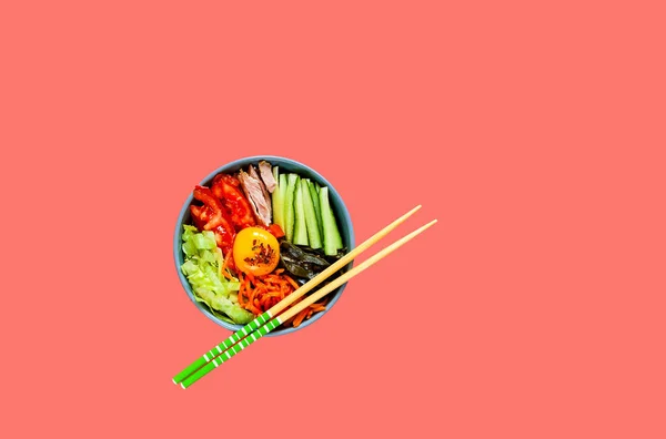 Traditional dish of Korean cuisine. Bibimbap with beef, vegetables and egg on coral background. — Stock Photo, Image
