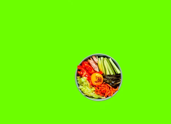 Tradycyjne danie kuchni koreańskiej. Bibimbap z wołowiną, warzywami i jajkiem na tle Ufo zielony. — Zdjęcie stockowe