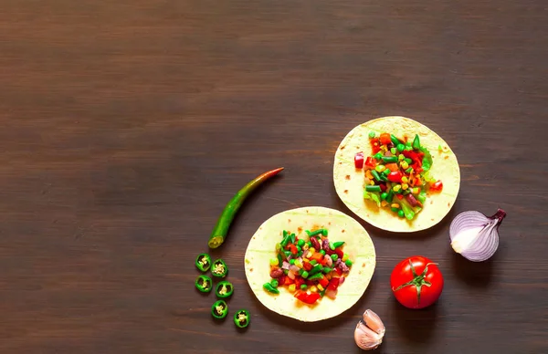 Traditionelle Gericht der mexikanischen Küche. Mais-Tortilla-Tacos mit Gemüsefüllung auf Holz-Hintergrund. — Stockfoto