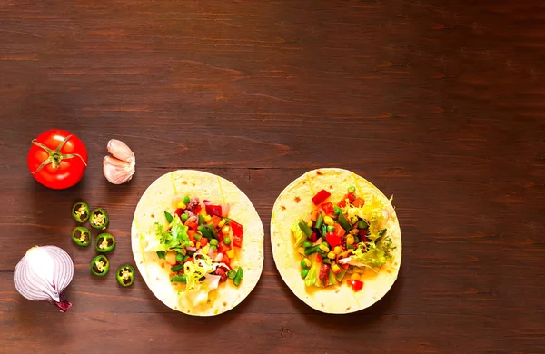 Traditionelle Gericht der mexikanischen Küche. Mais-Tortilla-Tacos mit Gemüsefüllung auf Holz-Hintergrund. — Stockfoto
