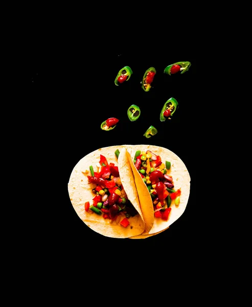 Plat traditionnel de la cuisine mexicaine. Tortilla de maïs tacos avec garniture de légumes sur fond noir . — Photo