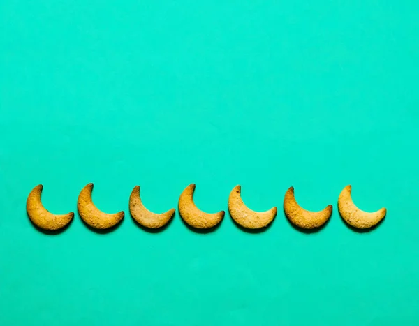 Yeşil arka plan üzerinde ay şeklinde kurabiye. Bayram veya Ramazan Festivali arka plan. — Stok fotoğraf
