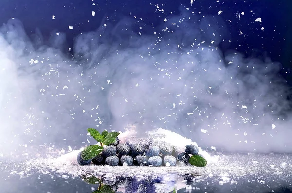 Blaubeeren im Hintergrund von Schnee und Rauch. — Stockfoto