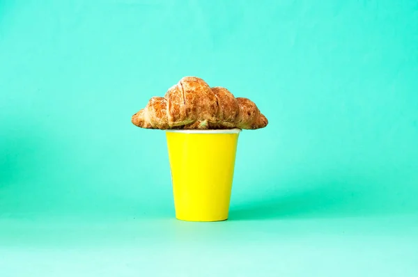 Croissant smörgåsar och kaffe i gul disponibel Cup. — Stockfoto