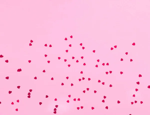 Fondo rosa festivo con lentejuelas en forma de corazón . — Foto de Stock