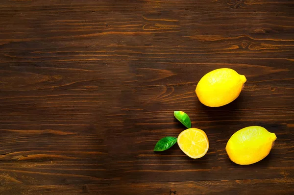 Citroner på mörkt träbord. Övervy, kopiera utrymme, närbild. — Stockfoto