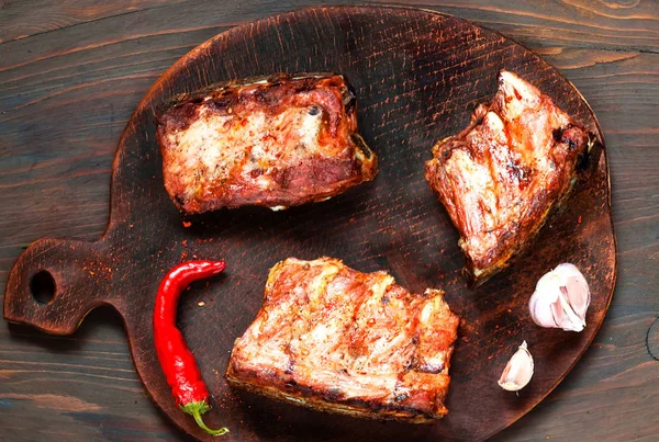 Costolette di ricambio piccanti alla griglia calde di barbecue servite con peperoncino piccante e lime su sfondo di legno scuro . — Foto Stock