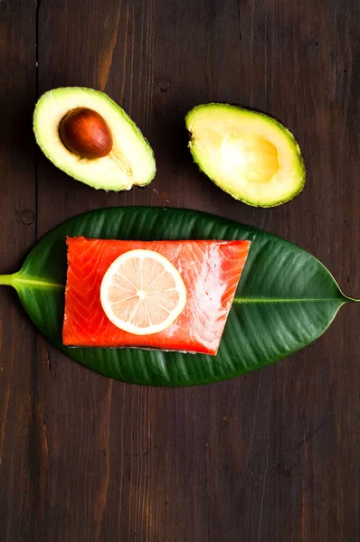 El concepto de comida orgánica.Filete de salmón y aguacate sobre fondo rústico . — Foto de Stock