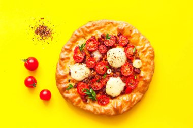 Parlak sarı arka planda ev yapımı pizza. Geleneksel İtalyan yemekleri kavramı. 