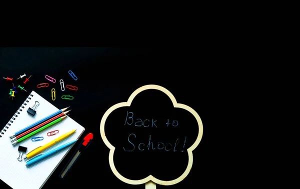 Torniamo a scuola sullo sfondo della lavagna. Forniture scolastiche su sfondo nero — Foto Stock
