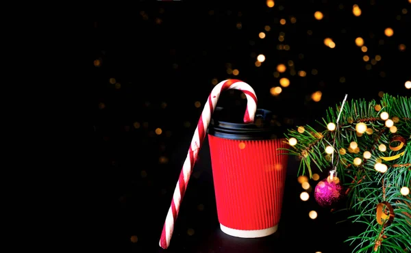 Рождественский декор. Кофе в разноцветной одноразовой чашке на фоне еловой ветви — стоковое фото