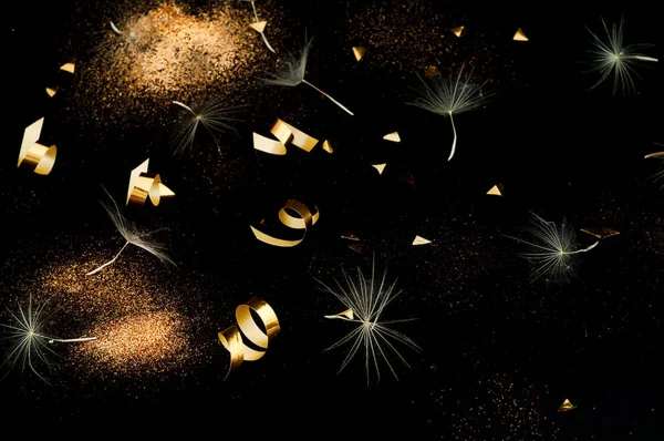 Inflorescências de dente de leão branco sobre fundo preto com brilhos dourados. Conceito para fundo festivo — Fotografia de Stock