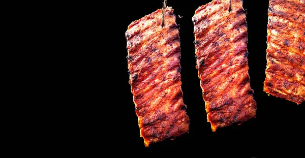 Fűszeres meleg sült bordák a grill fekete háttér. Conc — Stock Fotó