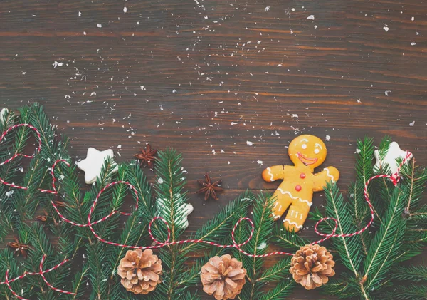 Ahşap arka planda Noel köknar dalları ve çam kozalası — Stok fotoğraf