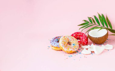 Renkli çörekler ve pembe bir sırt üzerinde hindistan cevizi.