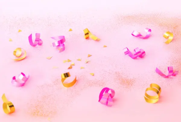 Κομφετί σε ροζ φόντο με χρυσές λάμψεις. Έννοια για εορταστική φόντο ή για το έργο. — Φωτογραφία Αρχείου
