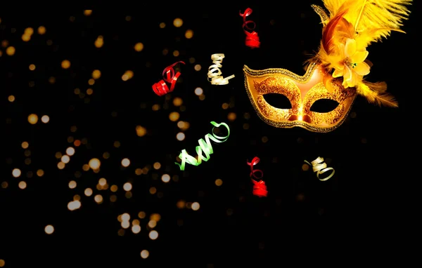 Masquerade mask on black background with sparkles. The concept of traditional holidays. Close-up, copy space