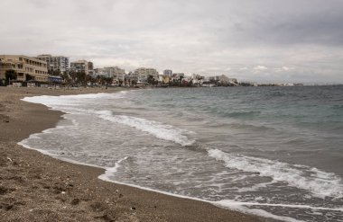 arka planda binalar ile İspanya'da bulutlu bir günde benalmadena plaj