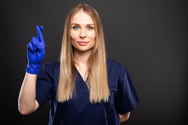 Copypsace reklam alanı siyah zemin üzerine parmak gösterilen önlük giyen güzel kadın dişçi geçti