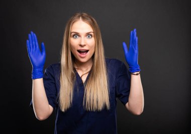 Giyen güzel kadın diş hekimi arıyorum scrubs mutlu ya da içerik siyah arka plan üzerine boşaltmak reklam alanı ile