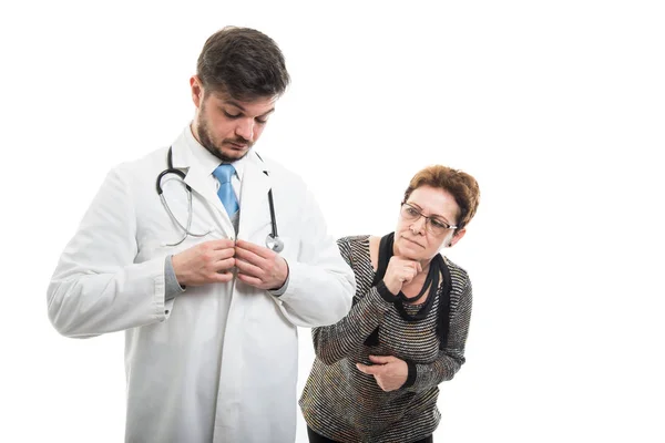 Paciente Sênior Que Olha Para Casaco Abotoamento Médico Masculino Isolado — Fotografia de Stock