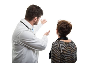 Bir erkek doktor bir şey beyaz arka plan üzerinde izole kadın kıdemli hastaya gösterilen arkadan görünüm
