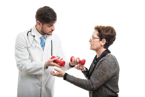 Médico Masculino Dando Dois Halteres Vermelhos Para Paciente Sênior Feminino — Fotografia de Stock