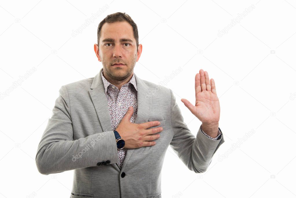 Portrait of business man showing oath gesture isolated on white background with copyspace advertising area