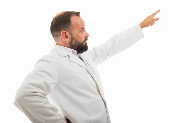 Copyspace 折込広告エリアで白い背景で隔離の指で指している男性医師の側面図 — ストック写真