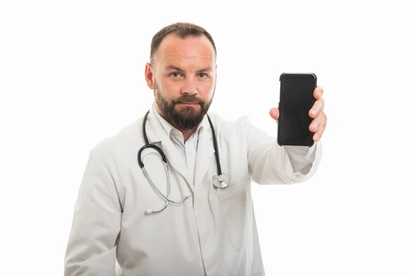 男性医生肖像显示智能手机与 Copyspace 广告区的白色背景下的相机隔离 — 图库照片
