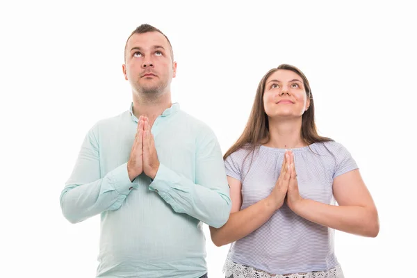 年轻幸福夫妇的肖像显示在白色背景上与 Copyspace 广告区隔离的祈祷手势 — 图库照片