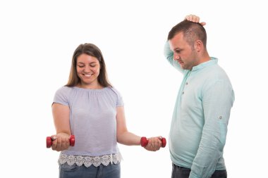 Boşaltmak reklam alan beyaz zemin üzerine izole kırmızı dumbbells gösterilen genç mutlu çift portresi