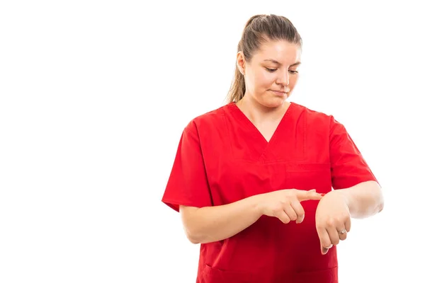 戴红色擦洗腕表的年轻医护护士肖像看手表手势在白色背景下与 Copyspace 广告区隔离 — 图库照片