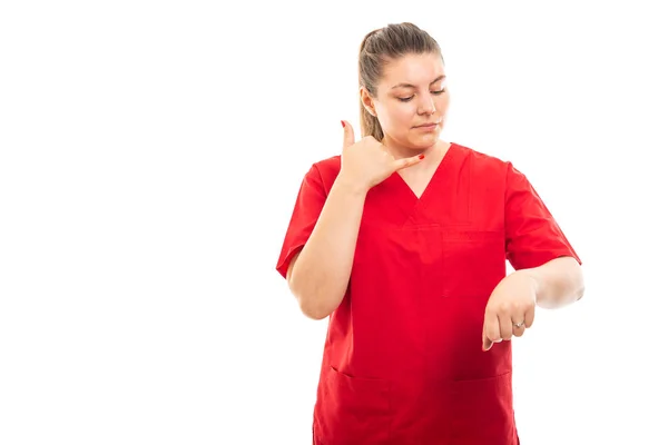 戴红色擦洗的年轻医护护士肖像制作电话预约手势在白色背景下与 Copyspace 广告区隔离 — 图库照片