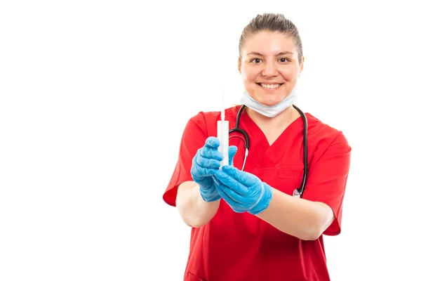 身穿红色擦洗的年轻医护护士肖像显示在白色背景下与 Copyspace 广告区隔绝的注射器 — 图库照片