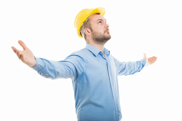 年轻建筑师的侧面看法以黄色头盔站立与张开的胳膊在白色背景隔绝了与 Copyspace 广告区域 — 图库照片
