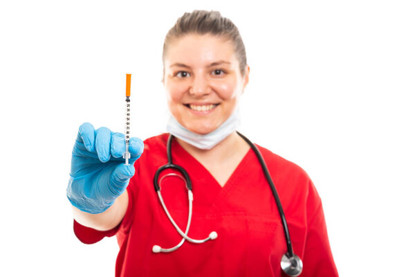 Selective focus of young medical nurse wearing red scrub showing diabetes shot isolated on white background with copyspace advertising area
