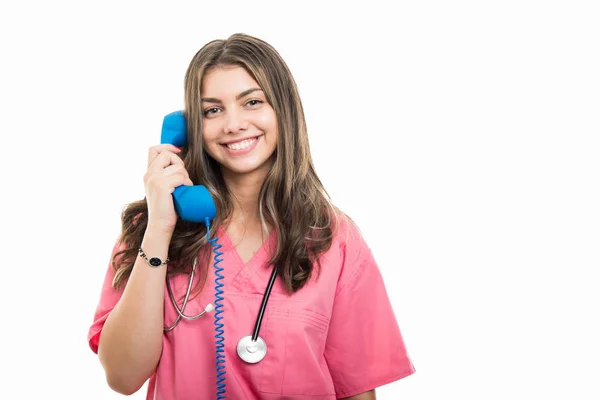 コピー領域の広告に白い背景に分離された電話の受話器で話している美しい若い医師の肖像画 — ストック写真