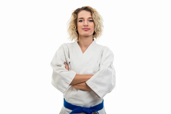 Portrait of female wearing martial arts uniform standing with arms crossed isolated on white background