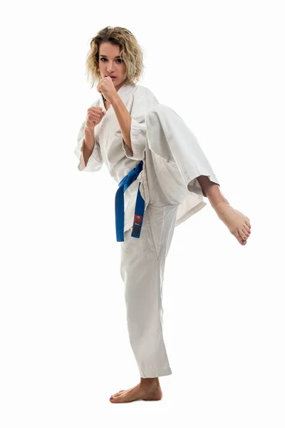 Female wearing martial arts uniform making karate move isolated on white background
